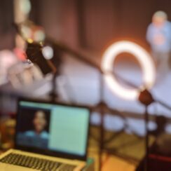 A technician sits behind a laptop whilst filming a performance