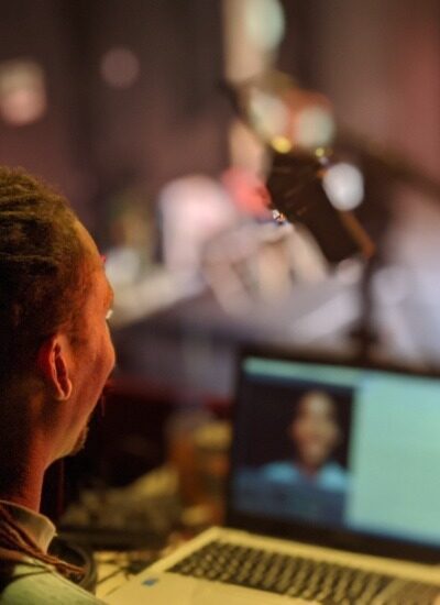 A technician sits behind a laptop whilst filming a performance