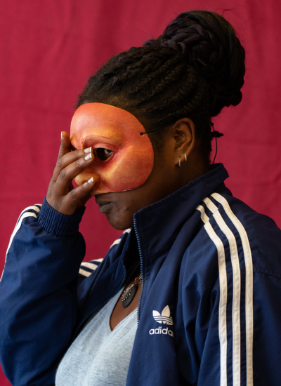 Practitioner, Liz, wears a mask mid performance