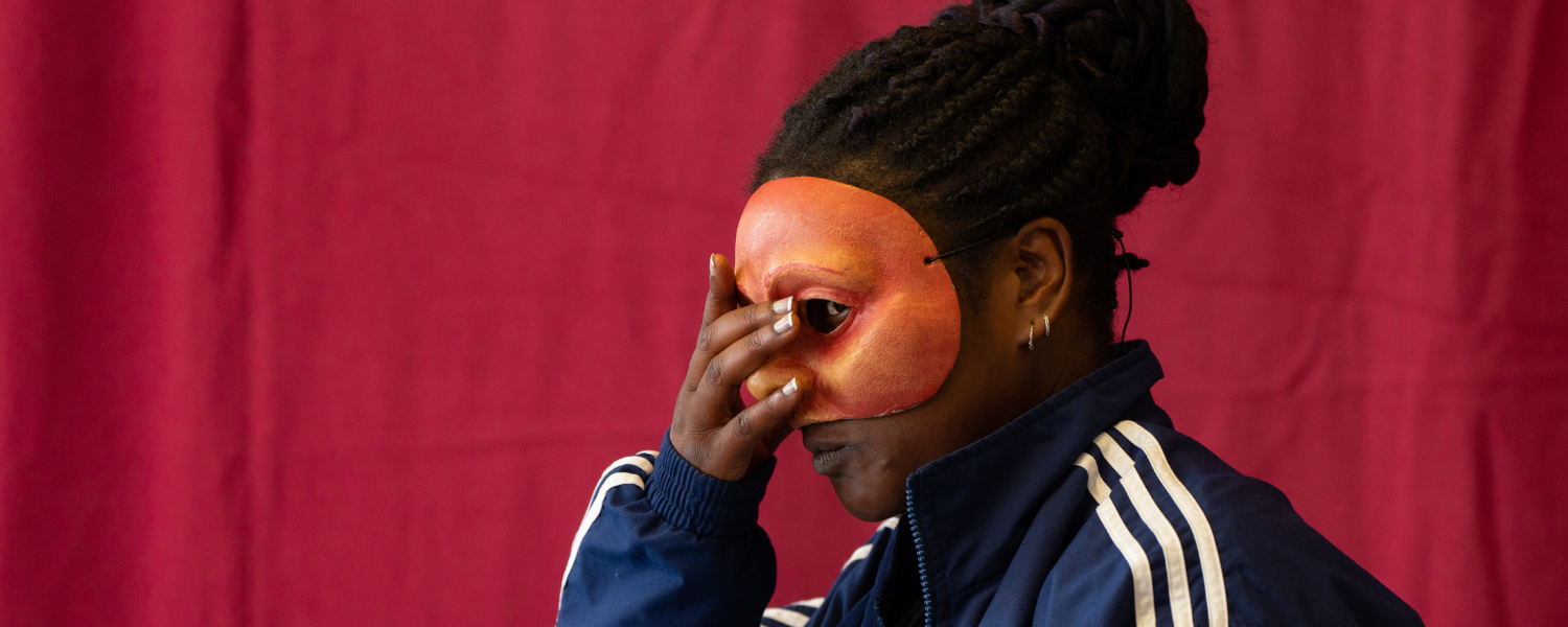 Practitioner, Liz, wears a mask mid performance